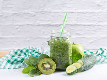 Green detox smoothie in jar on white background. healthy beverages concept.