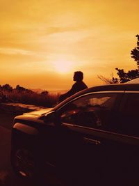 Cropped image of car on road at sunset