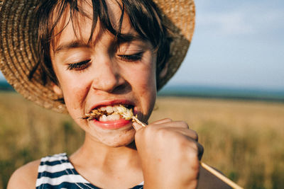 Close-up of boy eating crop at farm