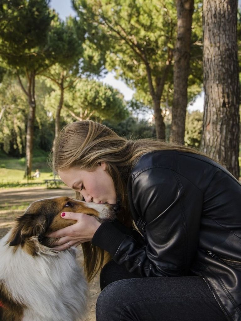 person, lifestyles, tree, leisure activity, young adult, headshot, focus on foreground, portrait, casual clothing, looking at camera, young women, smiling, park - man made space, front view, head and shoulders, animal themes, day