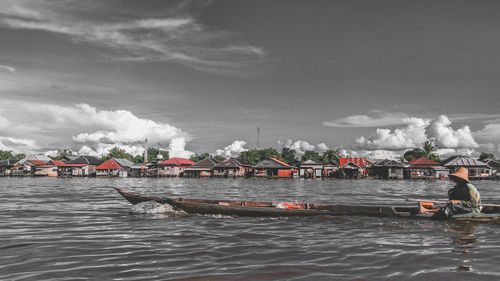 People on boat in sea against sky