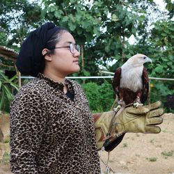 Young woman with hawks on plant