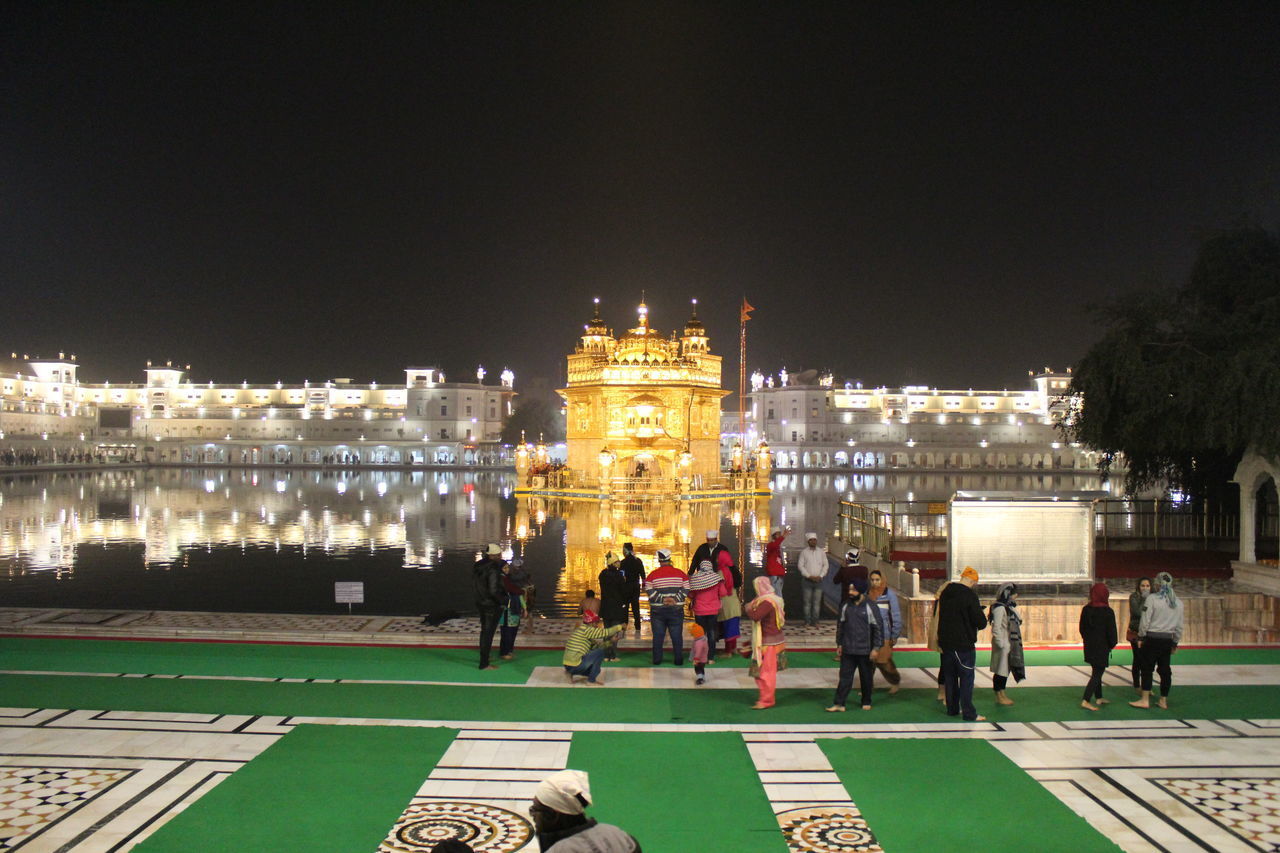 PEOPLE ON ILLUMINATED CITY AT NIGHT