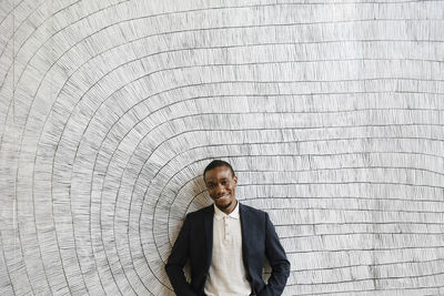 Smiling male professional standing in front of wall at convention center