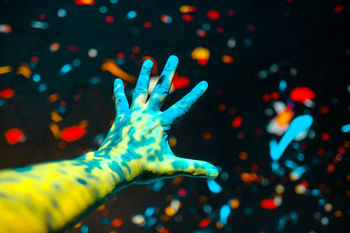 Close-up of human hand against illuminated light