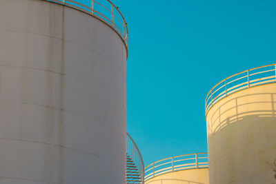 Low angle view of factory against clear blue sky