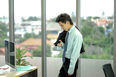 Man using mobile phone while standing on table