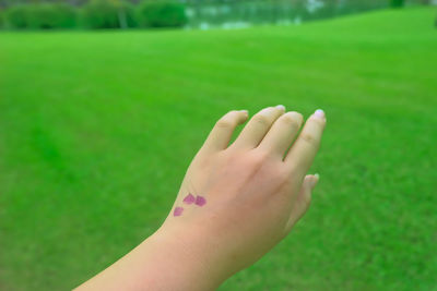 Close-up of woman hand on green leaf