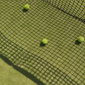 High angle view of tennis balls on grassy field in court