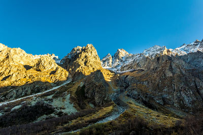 Scenic view of mountains against clear blue sky