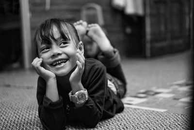 Smiling girl lying on carpet at home