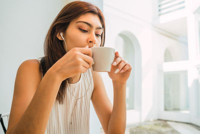 Young woman drinking coffee cup at home