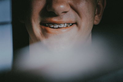 Close-up of smiling mid adult man against black background
