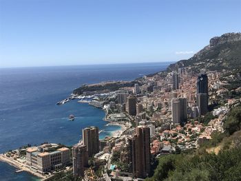 High angle view of buildings by sea against clear sky