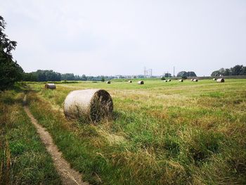 Hay bales on field against sky