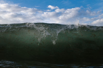 Wave breaking under sunset on a beach