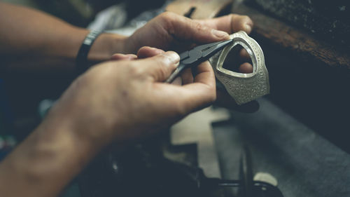 Midsection of man working on metal