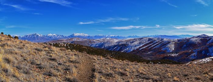 Panoramic view of snowcapped mountains against blue sky