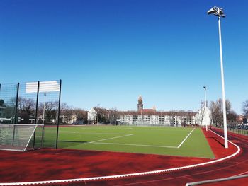 View of soccer field against clear blue sky