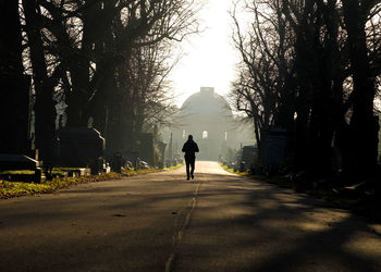 Rear view of man walking on road