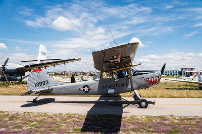 Airplane on airport runway against sky