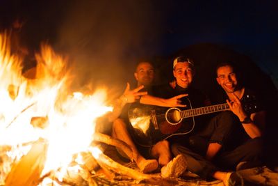 Young man playing guitar at night