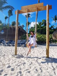 Full length of man on beach umbrella against sky