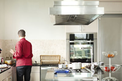 Rear view of woman preparing food at home