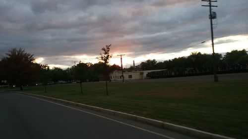 Empty road along countryside landscape at sunset