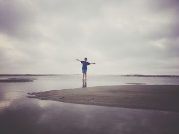 Man standing on beach against sky