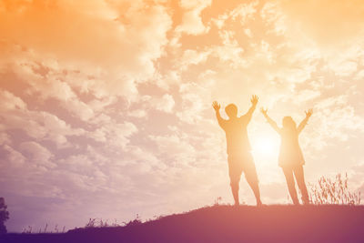 Silhouette people standing against sky during sunset