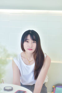 Portrait of young woman sitting on table