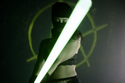 Close-up of masked woman holding a led light panel