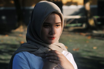 Portrait of young woman against blurred background