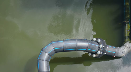 High angle view of black flexible hdpe pipes and bolted connection flange
