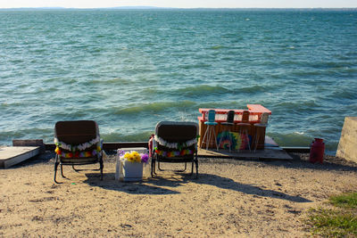 Deck chairs on beach by sea