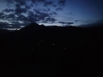 Low angle view of silhouette mountain against sky at night