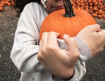 Midsection of man holding pumpkin
