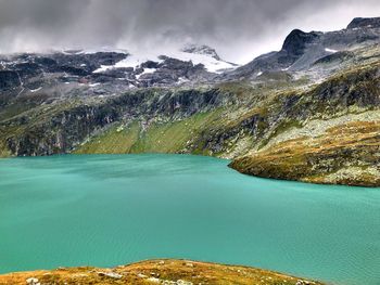 Scenic view of lake by mountains against sky