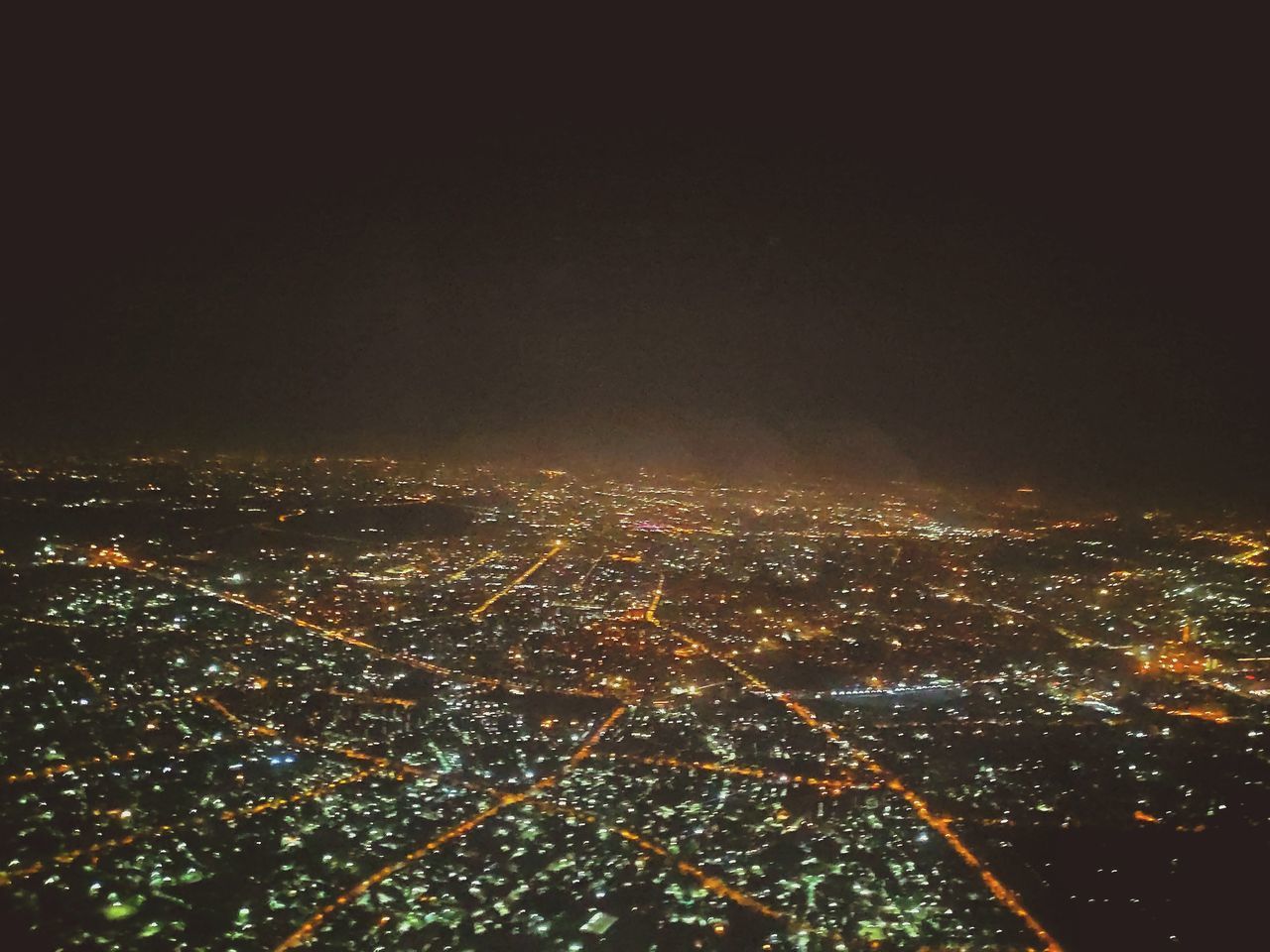 HIGH ANGLE VIEW OF ILLUMINATED BUILDINGS IN CITY AGAINST SKY