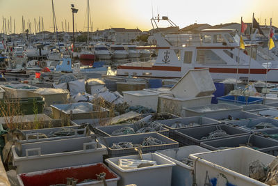 Fishing boats moored at harbor against sky