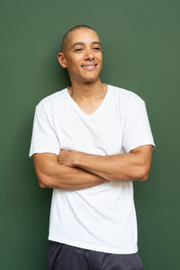 Portrait of young man standing against wall