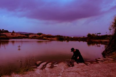 Side view of man in lake against sky