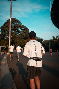 Rear view of people walking on street in city