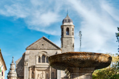 Low angle view of drinking fountain against church