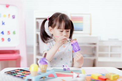 Young girl decorating hand made craft for homeschooling