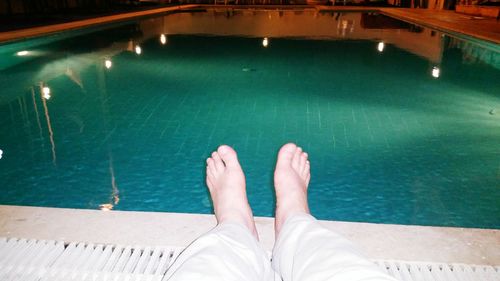 Low section of woman standing in swimming pool