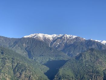 Scenic view of snowcapped mountains against clear blue sky