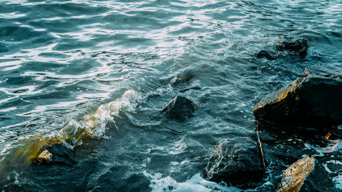 High angle view of waves splashing on rocks
