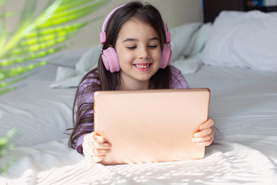 Girl with tablet pc lying on bed at home